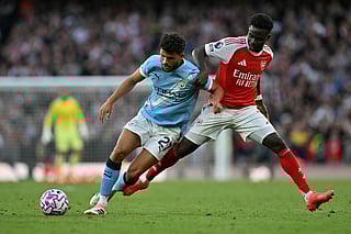 Manchester City's Portuguese midfielder Matheus Nunes (left) vies with Arsenal's English midfielder Bukayo Saka during the English Premier League football match at the Emirates Stadium in London on September 21, 2025.