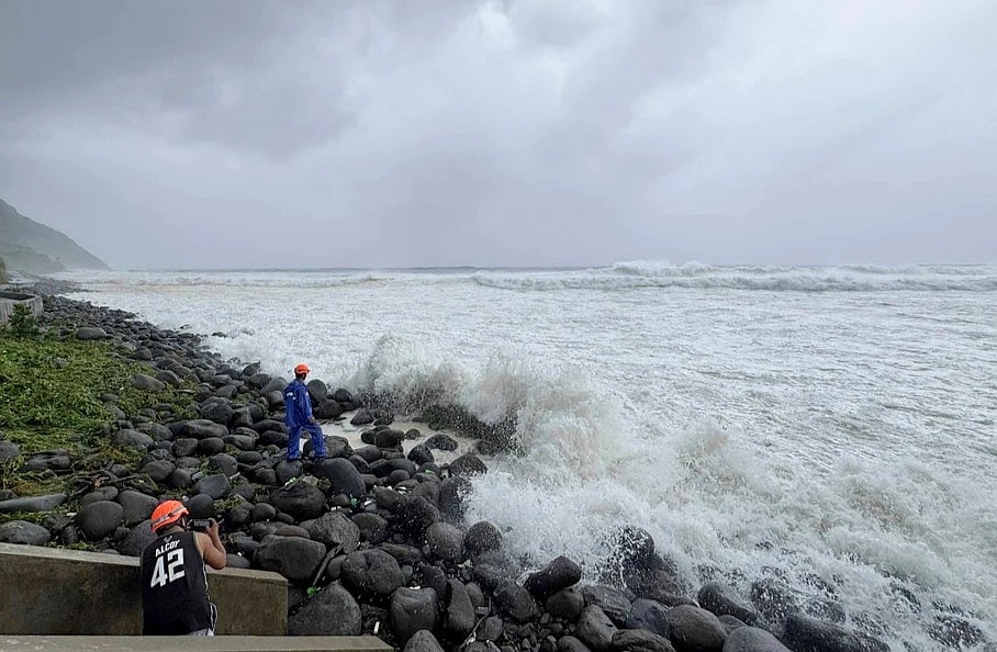 People watch as strong waves batter Basco, Batanes province, northern Philippines as Typhoon Ragasa affects the area on Monday, Sept. 22, 2025. 