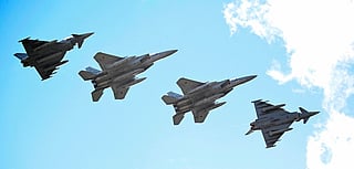 Eurofighter Typhoon (L and R) and Japanese Air Self-Defense Force F-15 fighter jets fly over the military air base in Laage, south of Rostock, northeastern Germany, during a demonstration as part of a press day on September 23, 2025.