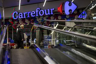 People pass-by the logo of the French supermarket chain Carrefour at the entrance to the store in the shopping mall in the Warsaws downtown, Poland, on September 22, 2025.
