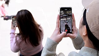 A file photo taken on November 28, 2024 shows young people looking at their phones in Melbourne as Australia looks to ban children under 16 from social media.