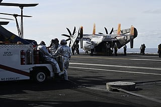 Firefighters stand on the deck of aircraft carrier USS Gerald R Ford.