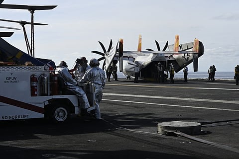 Firefighters stand on the deck of aircraft carrier USS Gerald R Ford.