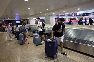 Passengers collect their luggage from conveyor belts at Dubai airports. File photo