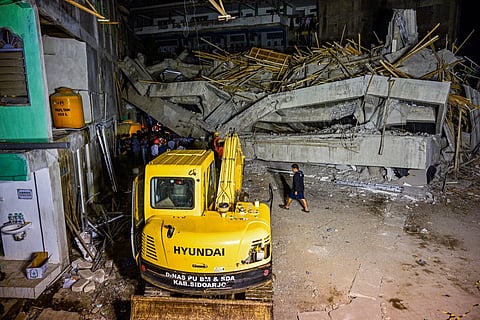 Rescue personnel and locals stand behind an excavator as they search for survivors after a building collapsed at an Islamic boarding school in Sidoarjo, East Java province on September 29, 2025, injuring a number of students and trapping several others under the rubble.