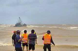 People work to rescue fishermen on a stranded fishing boat due to Typhoon Bualoi in Quang Tri, Vietnam Sunday, Sept. 28, 2025. 