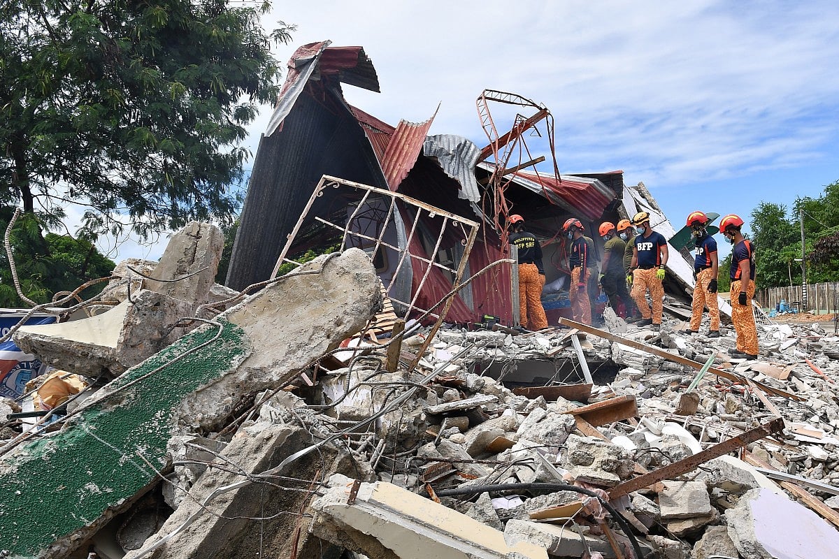 Rescuers search for people who were reported trapped under the rubble of a collapsed building in Bogo City on October 1, 2025, after a powerful 6.9 magnitude earthquake jolted the central Philippines, killing dozens on the island of Cebu with fears the toll could rise.