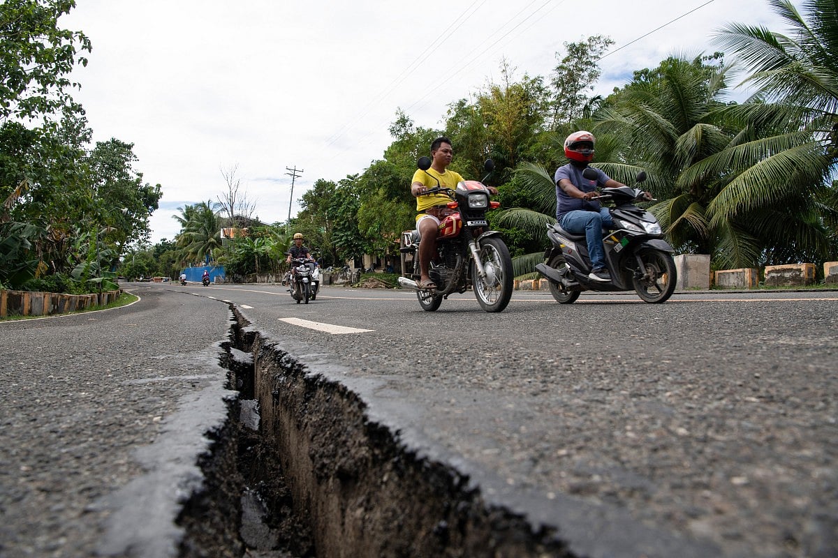 Motorists pass a crack in the road along a major highway in Tabogon town, Cebu province.