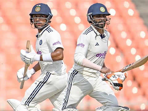 India's Ravindra Jadeja (R) and Dhruv Jurel run between wickets during the second day of the first Test match against West Indies at the Narendra Modi Stadium in Ahmedabad on October 3, 2025. 