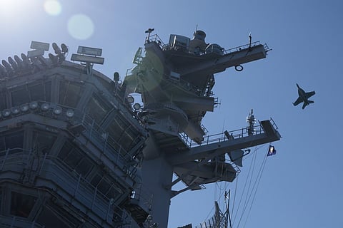 A warplane flies over the USS George H.W. Bush aircraft carrier on October 5, 2025 off the eastern coast of the United States.