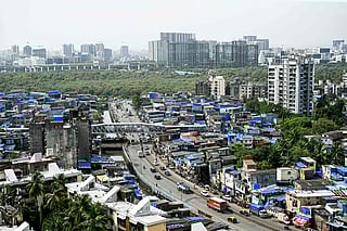 High-rise buildings tower over the densely packed homes of Dharavi, Mumbai’s sprawling slum settlement, in this photograph taken on July 12, 2025. A massive $8 billion redevelopment project, led by the Mumbai authorities and Adani Realty, aims to transform Asia’s largest slum into a modern urban district.