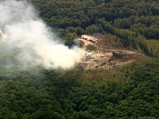 Smoke fills the air as debris covers the ground and vehicles after a powerful blast ripped through a military explosives manufacturing plant in Hickman County, Tennessee, on Friday, October 10, 2025.   