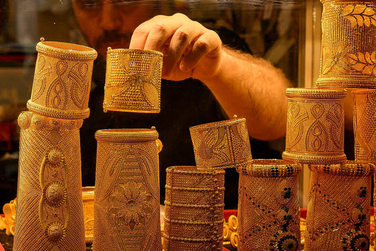 A salesperson displays gold bangles for sale in a gold shop at the Grand Baazar in Istanbul, on October 10, 2025.