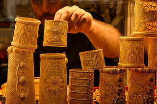 A salesperson displays gold bangles for sale in a gold shop at the Grand Baazar in Istanbul, on October 10, 2025.