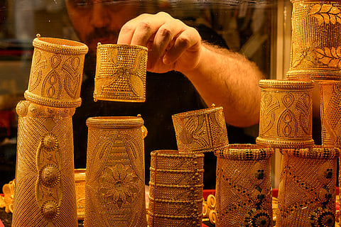 A salesperson displays gold bangles for sale in a gold shop at the Grand Baazar in Istanbul, on October 10, 2025.