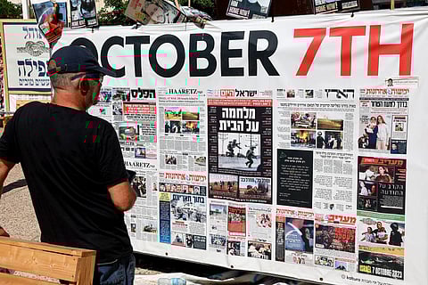 A man looks at front pages from Israeli newspapers marking the October 7, 2023 attacks, outside the Tel Aviv Museum of Art, known as the "Hostages' Square" in Tel Aviv, Israel, October 11, 2025.