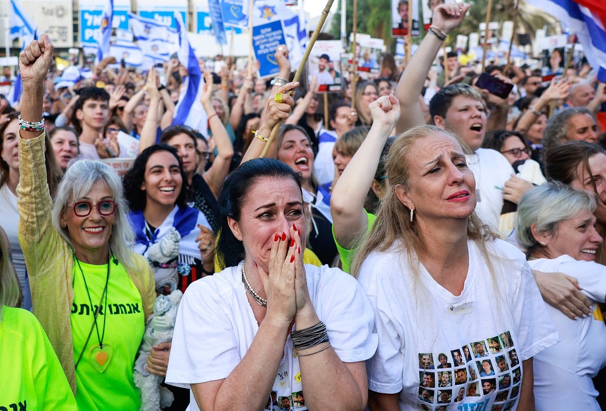 A woman reacts as people celebrate at Hostage Square in Tel Aviv as news came out that a Red Cross convoy is on its way to pick up a second group of Israeli hostages to be freed by Hamas on October 13, 2025.