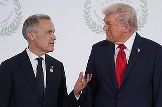 US President Donald Trump greets Canada's Prime Minister Mark Carney during a summit on Gaza in Sharm el-Sheikh on October 13, 2025.