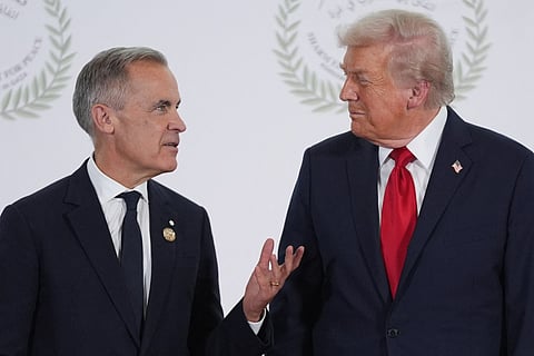 US President Donald Trump greets Canada's Prime Minister Mark Carney during a summit on Gaza in Sharm el-Sheikh on October 13, 2025.