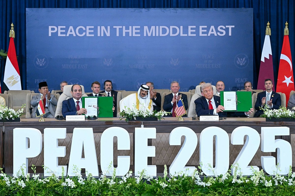 Trump (right) and Egypt's President Abdul Fattah Al Sissi show signed documents during a summit on Gaza in Sharm Al Sheikh on October 13, 2025.