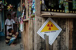 A warning sticker labelled “Danger Radiation” with a handwritten note showing “23.9 microsieverts per hour” is seen on the wall of a kiosk in front of a house next to the Modern Cikande Industrial Estate, where the radioactive isotope Caesium 137 was detected, in Sukatani, Banten province on October 13, 2025.