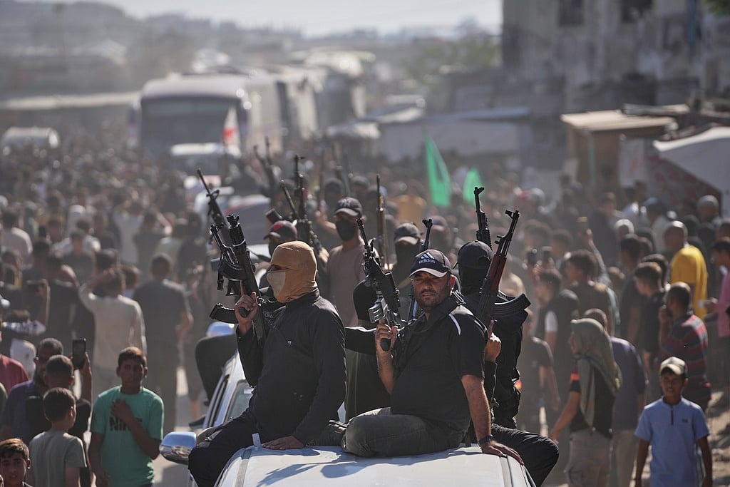 Hamas gunmen on pickup trucks escort buses carrying freed Palestinian prisoners as they are greeted following their release from Israeli jails under a cease-fire agreement between Hamas and Israel, in Khan Younis, southern Gaza Strip, Monday, Oct. 13, 2025. 