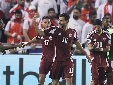 Qatar's Boualem Khoukhi, center, celebrates after scoring the opening goal against United Arab Emirates during the 2026 World Cup qualifying soccer match between Qatar and United Arab Emirates at the Hamad Bin Jassim Stadium in Doha.