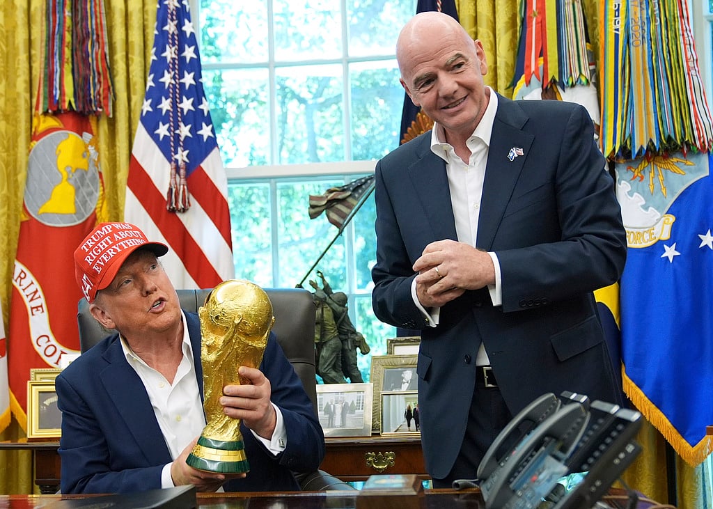 President Donald Trump holds the FIFA World Cup Winners Trophy as FIFA President Gianni Infantino looks on during an announcement in the Oval Office of the White House, Aug. 22, 2025, in Washington.