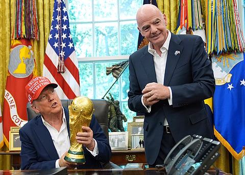 President Donald Trump holds the FIFA World Cup Winners Trophy as FIFA President Gianni Infantino looks on during an announcement in the Oval Office of the White House, Aug. 22, 2025, in Washington.