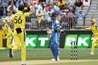 India's Virat Kohli (C) reacts as Australia’s paceman Mitchell Starc (front L) celebrates his wicket during the first one-day international cricket match between Australia and India in Perth on October 19, 2025.