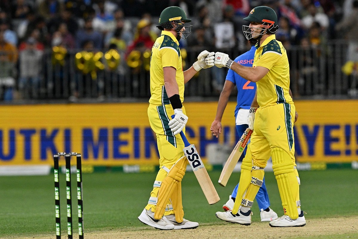 Australia's Matt Renshaw (L) and Mitchell Marsh exchange bump gloves during the first one-day international cricket match between Australia and India in Perth on October 19, 2025.