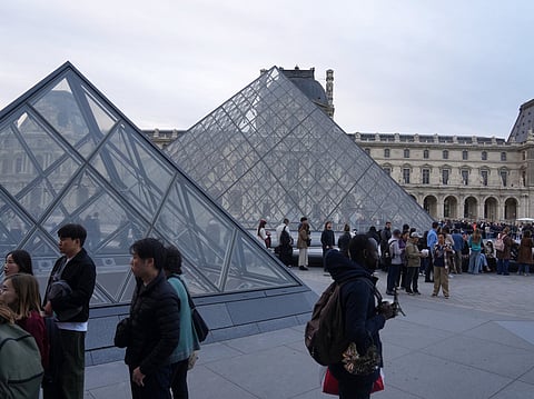 Visitors queue to enter the Louvre museum three days after historic jewels were stolen in a daring daylight heist, Wednesday, Oct. 22, 2025 in Paris. 