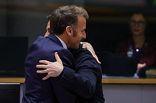 Ukraine's President Volodymyr Zelensky (back) is welcomed by France's President Emmanuel Macron at a European Council meeting gathering the 27 EU leaders to discuss Ukraine, European defence, recent developments in the Middle East, competitiveness, housing and migration, in Brussels on October 23, 2025.
