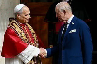 Pope Leo XIV shakes hands with Britain's King Charles III in San Damaso courtyard during a State visit to the Vatican on October 23, 2025.