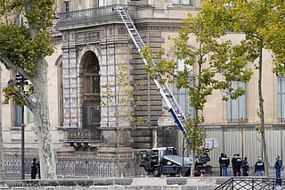 Police officers work by a basket lift used by thieves Sunday, Oct. 19, 2025 at the Louvre museum in Paris.