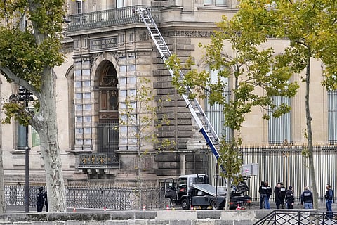 Police officers work by a basket lift used by thieves Sunday, Oct. 19, 2025 at the Louvre museum in Paris.