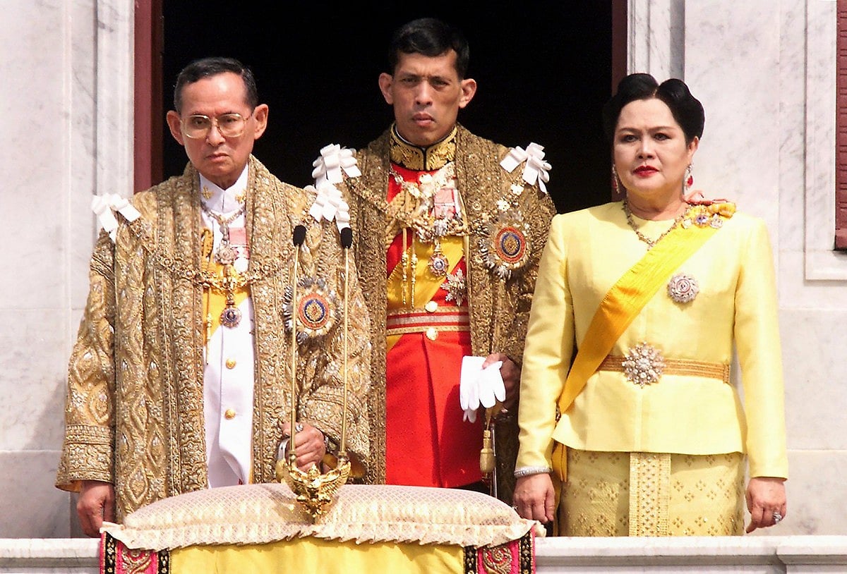 The Thai royal family (L-R) King Bhumibol Adulyadej, Crown Prince Maha Vajiralongkorn and Queen Sirikit receive respects from attending dignitaries at a balcony of Anantasamakom Throne Hall to mark the King's birthday on December 5, 1999.