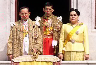 The Thai royal family (L-R) King Bhumibol Adulyadej, Crown Prince Maha Vajiralongkorn and Queen Sirikit receive respects from attending dignitaries at a balcony of Anantasamakom Throne Hall to mark the King's birthday on December 5, 1999.