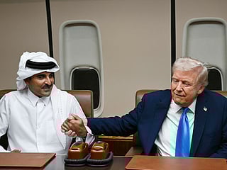 US President Donald Trump greets Qatar’s Emir Sheikh Tamim bin Hamad Al Thani (L) during a meeting aboard Air Force One in Doha on October 25, 2025, as he makes a refuelling stop on his way to Malaysia for the ASEAN summit. 