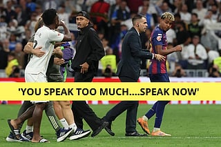 Real Madrid's Brazilian forward #07 Vinicius Junior (L) argues with Barcelona's Brazilian forward #11 Raphinha (C) and Barcelona's Spanish forward #10 Lamine Yamal (R) at the end of the Spanish league football match between Real Madrid CF and FC Barcelona at Santiago Bernabeu Stadium in Madrid on October 26 , 2025.