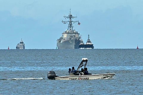 A speedboat of the Trinidad and Tobago Coast Guard patrols as the USS Gravely warship is seen at a distance from Port of Spain on October 26, 2025.