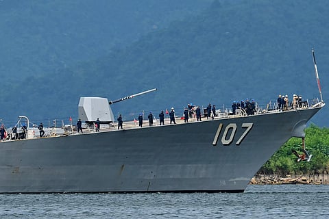 Crew of the USS Gravely warship stand on the bow of the vessel as it enters the port of Port of Spain on October 26, 2025.