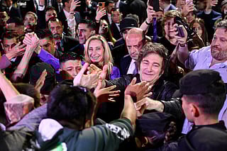Argentina's President Javier Milei (C-R) and his sister, the General Secretary of the Presidency Karina Milei, greet supporters as they celebrate outside the ruling party's La Libertad Avanza headquarters after the results of the national midterm legislative election in Buenos Aires on October 26, 2025.