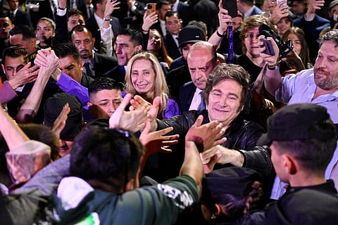 Argentina's President Javier Milei (C-R) and his sister, the General Secretary of the Presidency Karina Milei, greet supporters as they celebrate outside the ruling party's La Libertad Avanza headquarters after the results of the national midterm legislative election in Buenos Aires on October 26, 2025.