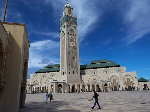 People walk past the great Hassan II Mosque in Casablanca, Morocco