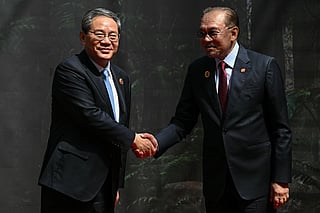 China's Premier Li Qiang, left, shakes hands with Malaysia's Prime Minister Anwar Ibrahim as he arrives at the Kuala Lumpur Convention Centre to attend the 47th Association of Southeast Asian Nations (ASEAN) summit in Kuala Lumpur, Malaysia, Monday, Oct. 27, 2025. 