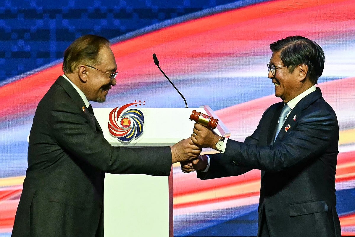 Philippines' President Ferdinand Marcos Jr (R) is given the ceremonial gavel by Malaysia's Prime Minister Anwar Ibrahim (L) during the ASEAN chairmanship handing over ceremony as part of the closing ceremony of the 47th Association of Southeast Asian Nations (ASEAN) Summit in Kuala Lumpur on October 28, 2025.