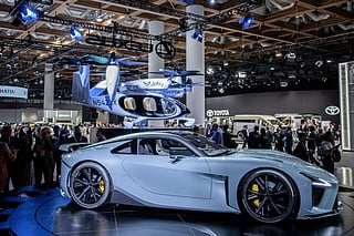 Members of media gather at the booths of Toyota and its luxury vehicle division Lexus during the press day of the Japan Mobility Show in Tokyo on October 29, 2025.