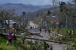 Residents walk through Lacovia Tombstone, Jamaica, in the aftermath of Hurricane Melissa, Wednesday, Oct. 29, 2025. 