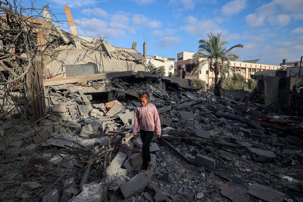A girl walks amid the rubble of a house destroyed in an Israeli strike in Nuseirat, in the central Gaza Strip, on October 29, 2025.